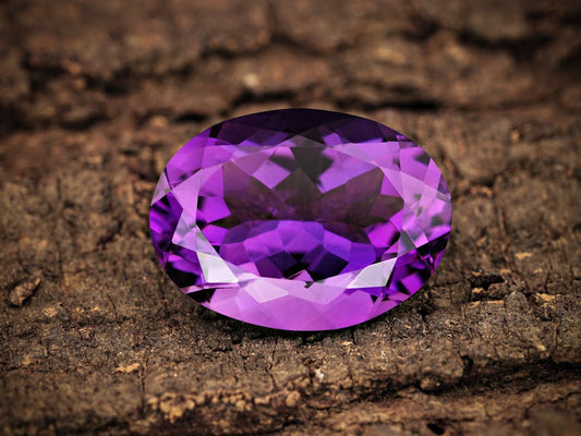 Twelve faceted gemstones representing the zodiac birthstones, arranged in a circle showing varied colors from blue sapphire to orange citrine