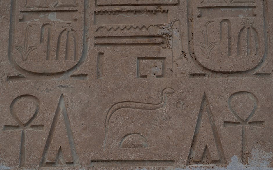 Carved stone relief showing ankh hieroglyph at ancient Egyptian temple, detail of wall inscription