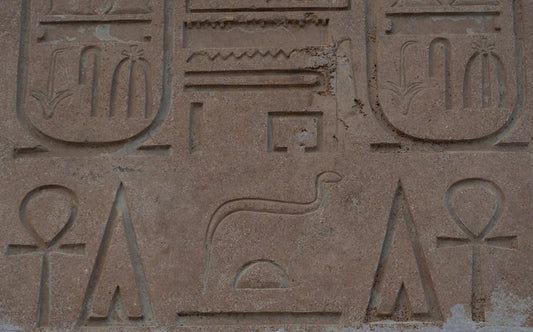 Carved stone relief showing ankh hieroglyph at ancient Egyptian temple, detail of wall inscription