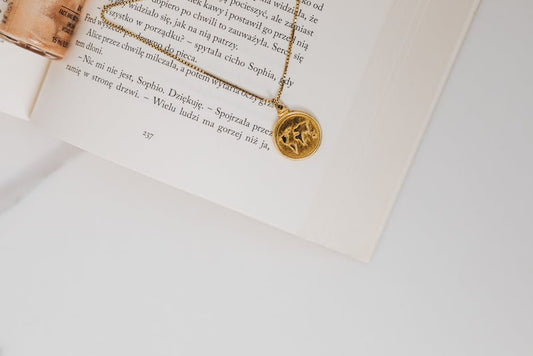 Delicate gold star pendant necklace on a clean surface — five-pointed star in solid gold
