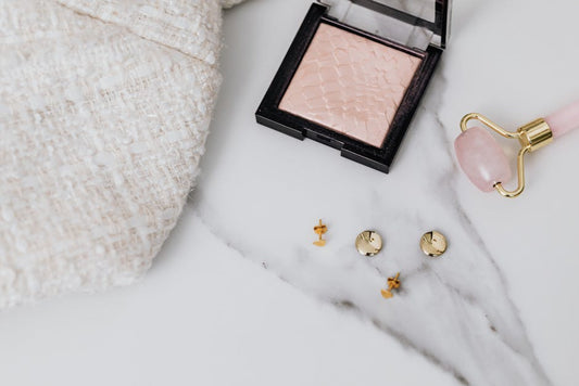 Symbolic jewelry pieces — hamsa, lotus, and crescent moon pendants arranged on white marble surface